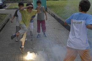 Unos niños juegan estallando petardos en el suelo. ::
SUR
