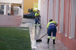 Operarios limpian la acera de una calle. :: Fernando González