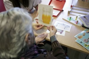 Una anciana examina una fotografía en un centro especializado en Alzheimer. ::
SUR