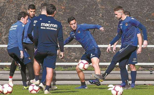 Mikel Merino y Adnan Januzaj pugnan por un balón en Zubieta ante la presencia de varios compañeros