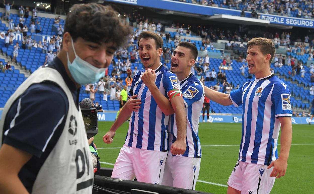 Oyarzabal celebra el gol del triunfo con la grada Zabaleta mientras es sujetado por Barrenetxea ante la presencia de Aihen. 