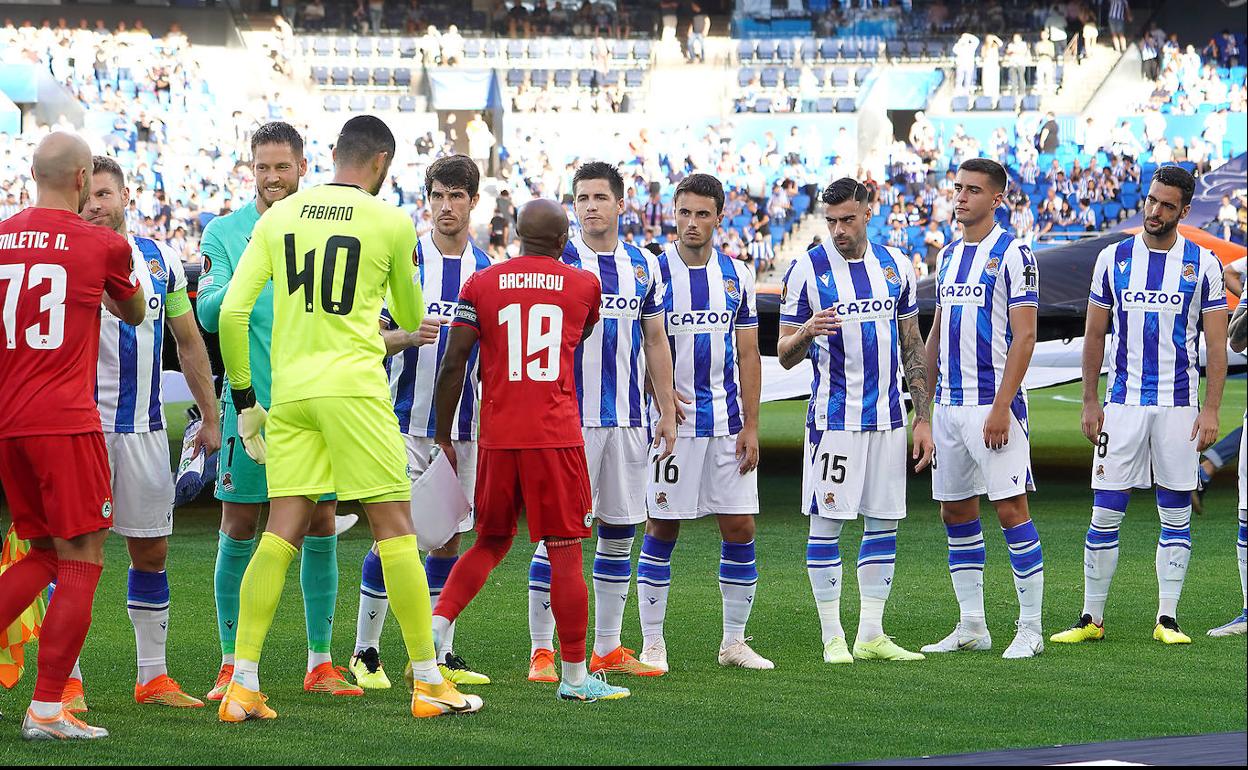 Los jugadores de la Real saludan a los futbolistas del Omonia Nicosia antes de iniciar el primer partido europeo de este curso en el Reale Arena.