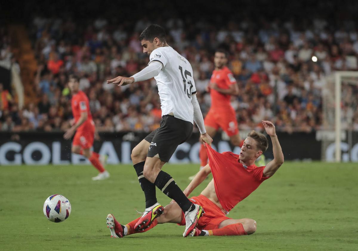Beñat Turrientes disputa el balón a Özkacar en el encuentro de ayer ante el Valencia.