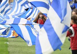 Una joven ondea la bandera de la Real antes de un partido en Anoeta.