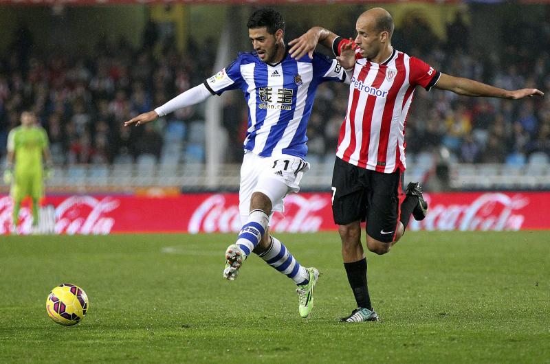 Carlos Vela y Mikel Rico pelean por un balón.