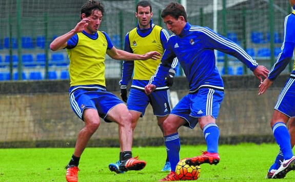 Mikel Oyarzabal trata de recortar con el interior del pie ante la presión de Granero ayer en Zubieta, mientras Agirretxe sigue de cerca la jugada. 