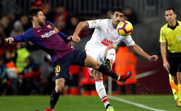 Messi y Cote pelean por un balón en el duelo del domingo en el Camp Nou.