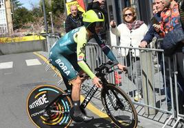 Roglic da la vuelta tras equivocarse en el recorrido mientras una aficionada le señala la dirección correcta.