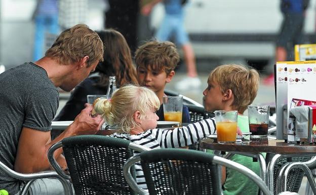 Una familia de turistas extranjeros coge fuerzas en un establecimiento donostiarra.