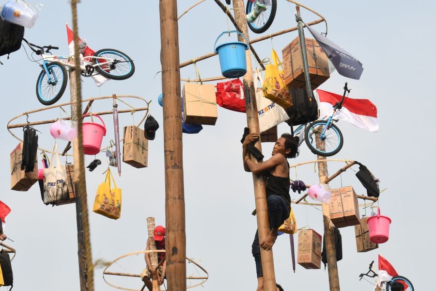 Indonesia celebra su 72 aniversario de independencia y por ello, a lo largo del territorio, se celebra la tradicional 'Panjat Pinang'. En una explanada se colocan arboles tallados, previamente lubricados con regalos en la parte más alta y los nativos deben alcanzar la cima para conseguir los presentes.