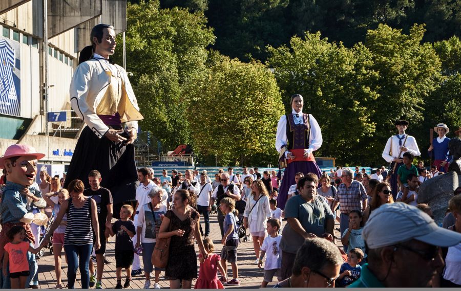 La comparsa de Gigantes y Cabezudos recorre el barrio de Amara, dentro de las actividades de Semana Grande. A las 18.30 horas el grupo ha salido desde Morlans. 