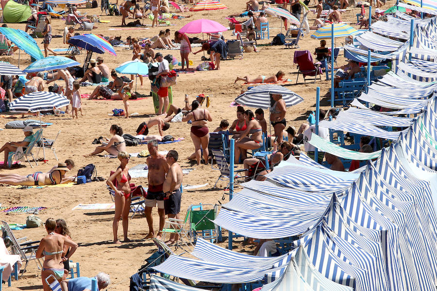 El fuerte calor ha hecho que las playas guipuzcoanas presenten este lunes una masiva alfuencia de gente. En las imágenes el malecón de Zarautz.