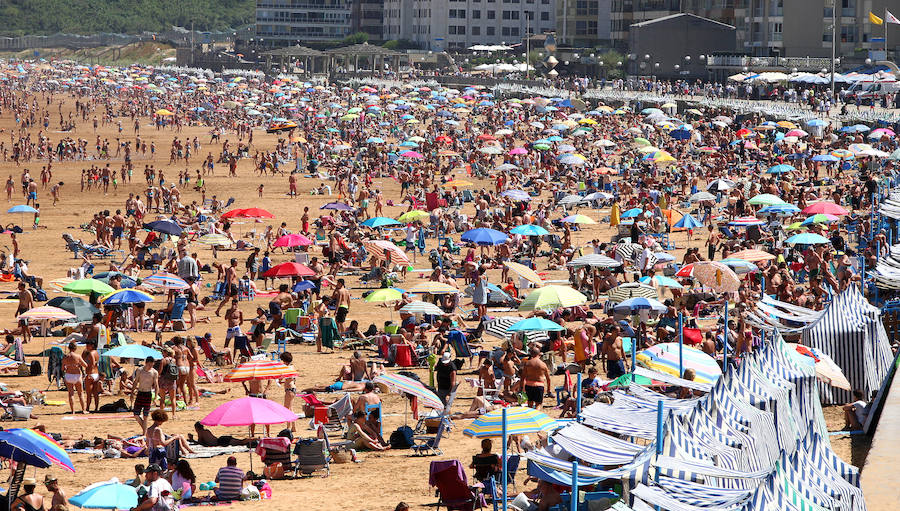El fuerte calor ha hecho que las playas guipuzcoanas presenten este lunes una masiva alfuencia de gente. En las imágenes el malecón de Zarautz.