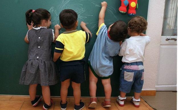 Un grupo de niños pinta en una pizarra. 