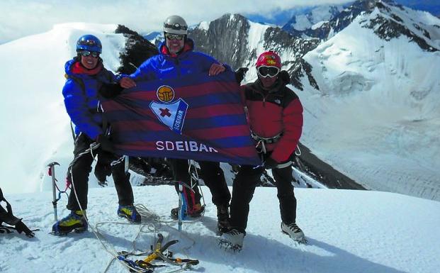 Elena Julián, Roberto Ruiz y el sherpa, con la bandera del Eibar. 