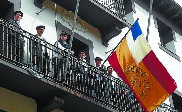 Aita Manuel y sus remeros desfilaron con la bandera original de 1917. A la derecha, la escena en Torreatze. Abajo, ondeando la bandera en la Tenencia.