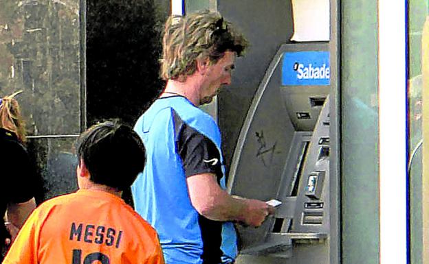 Un cliente retira dinero en una sucursal bancaria de Barcelona.