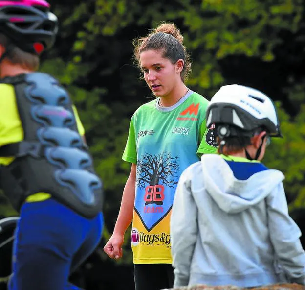 La piloto tolosarra durante una de sus clases de bike trial junto con sus alumnos, y un momento de la competición en Amberes. 
