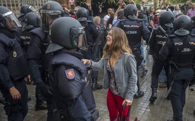 Una joven llora durante la operación de los agentes antidisturbios de la Policía Nacional.