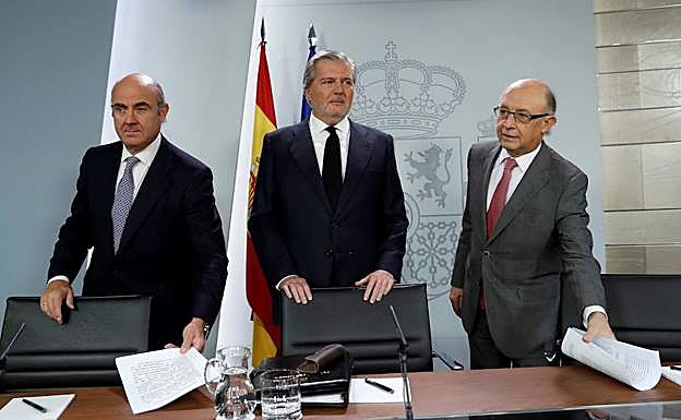 Íñigo Méndez de Vigo, Luis de Guindos y Cristóbal Montoro, durante la rueda de prensa posterior a la reunión del Consejo de Ministros que ha tenido lugar este viernes en el Palacio de La Moncloa.