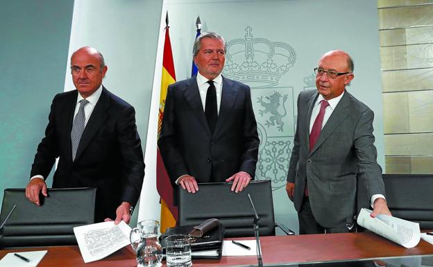 Los ministros De Guindos, Méndez de Vigo y Montoro, ayer en la rueda de prensa en Moncloa.