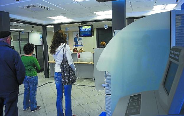 Un grupo de clientes espera para ser atendidos en una sucursal bancaria en Donostia. 
