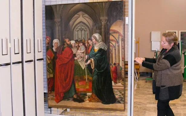 Una trabajadora del Museo de Zaragoza muestra una de las tablas. 