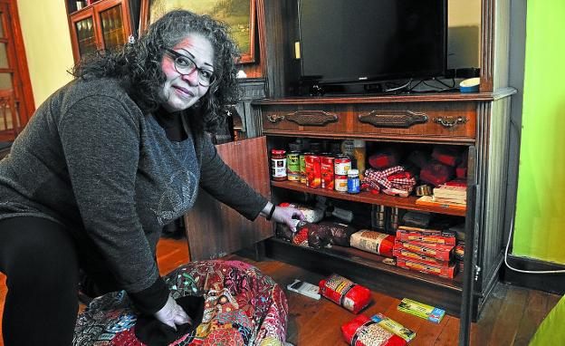 La mexicana Esther Avellano muestra la despensa donde guarda los alimentos que recibe cada mes.