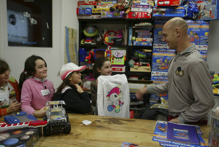 Richard Oribe con un grupo de niños durante la visita realizada a un mercadillo solidario de juguetes. 