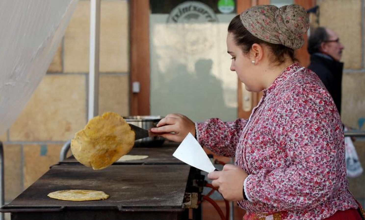 Mayores y niños disfrutan de los talos y la txistorra que se ofrecen en lo diferentes puestos de la localidad