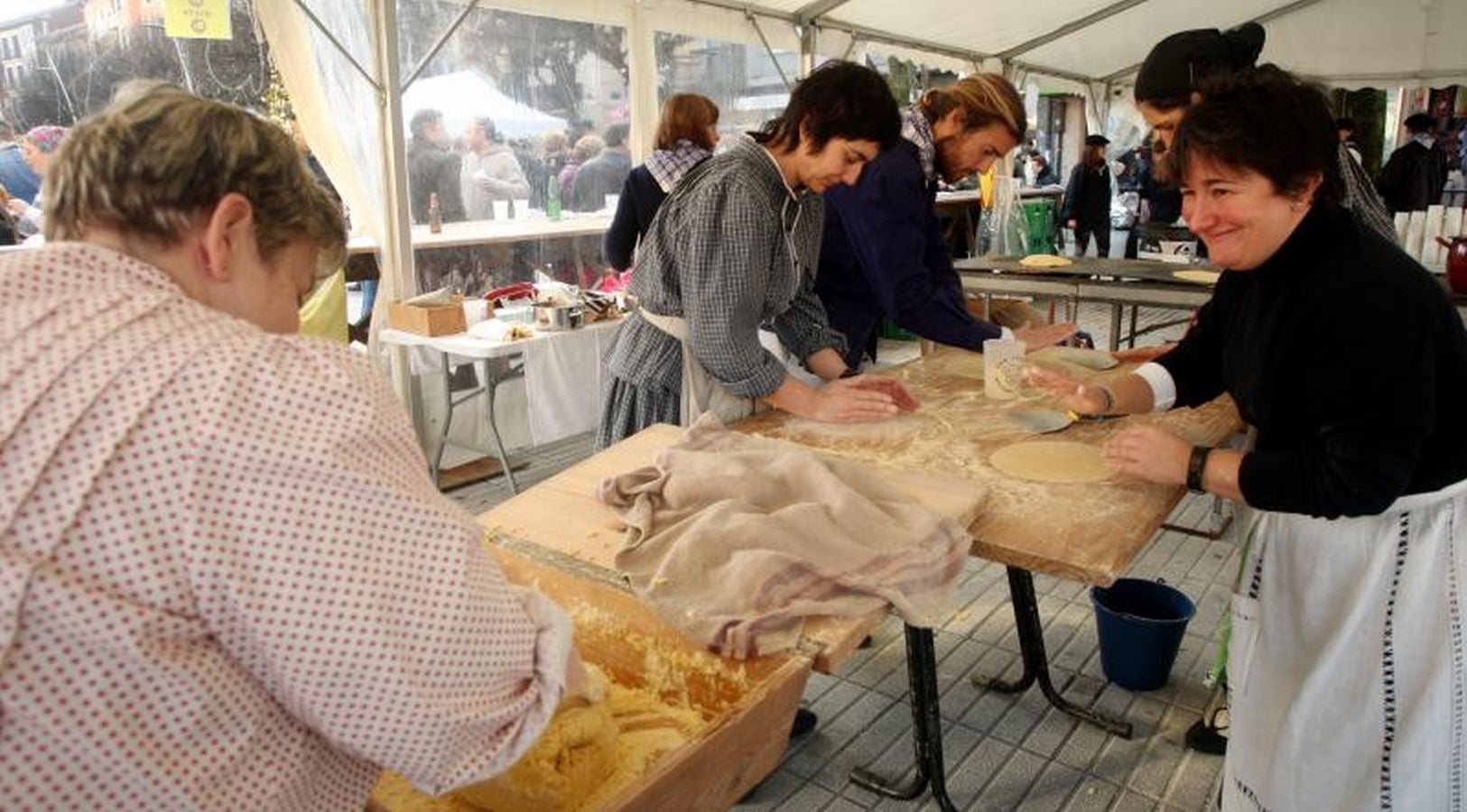 Mayores y niños disfrutan de los talos y la txistorra que se ofrecen en lo diferentes puestos de la localidad