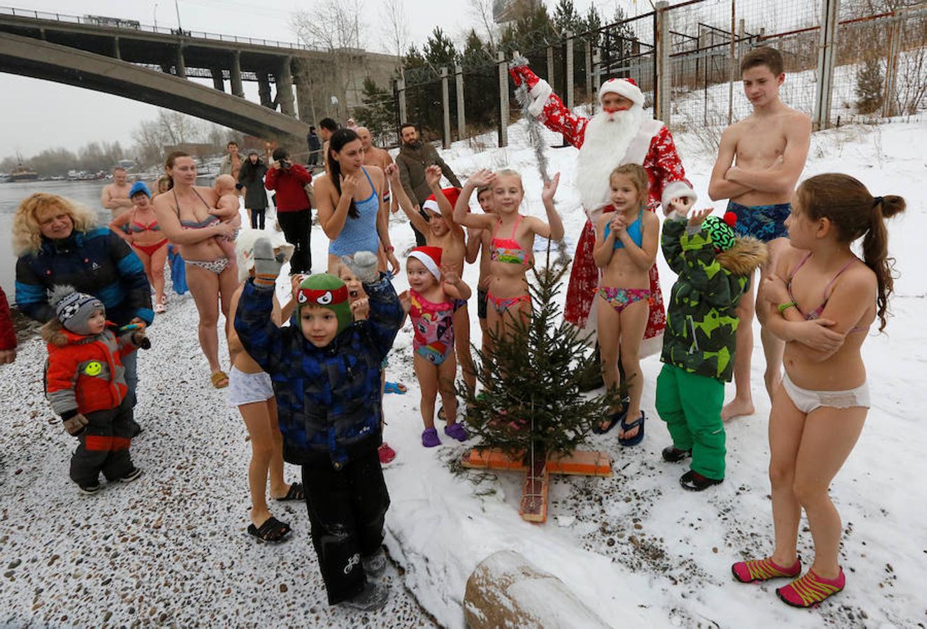 Miembros del club de nadadores de invierno Cryophile amateurs y sus hijos, acompañados por el padre Frost, el equivalente ruso de Santa Claus, se dan un baño en el río Yenisei, Rusia. Esta es su forma de celebrar la llegada de la Navidad y el Año Nuevo.