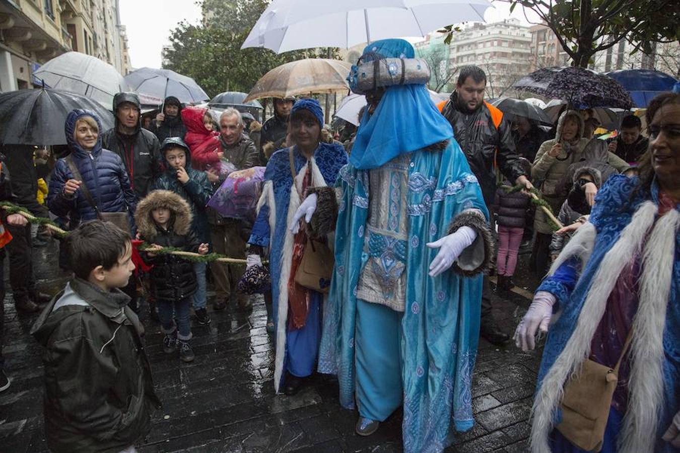 Los Reyes Magos han llegado este año por el río Urumea. Tras visitar el mercado navideño han iniciado una gira por los barrios, comenzando por Gros y sin dejarse el Hospital Donostia.