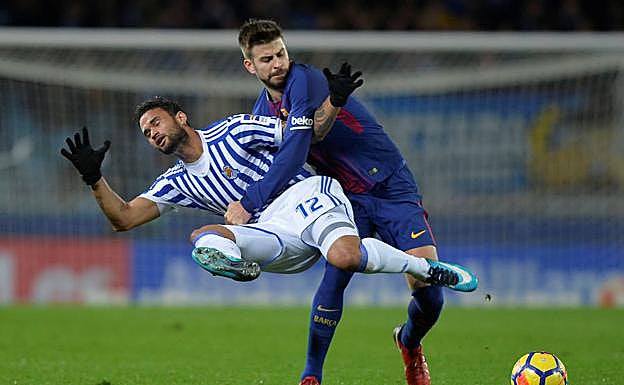 Piqué sujeta a Willian José en un lance del partido. 