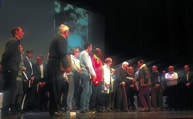 Imagen de la gala en honor a los ganadores del Cross Muguerza durante estos 75 años, donde Lucas Larraza y Mariano Haro se dan la mano. 