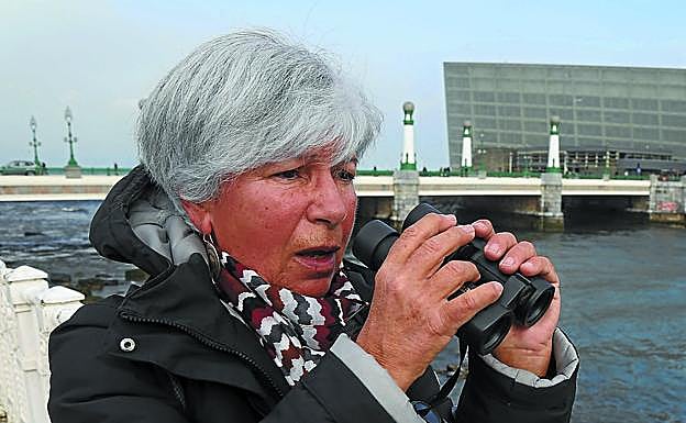 También avistamos un pequeño colirrojo . Ana, recién llegada de Galicia, otea el río desde la barandilla. Con sus prismáticos de pajarera. 