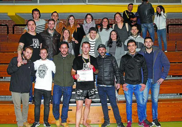 El campeón, con su diploma y su medalla, rodeado de amigos.