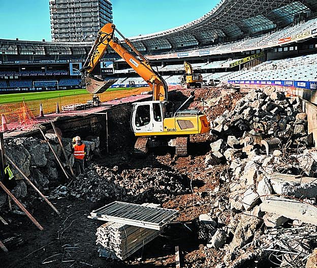 Una excavadora trabaja en la tribuna este del estadio. 