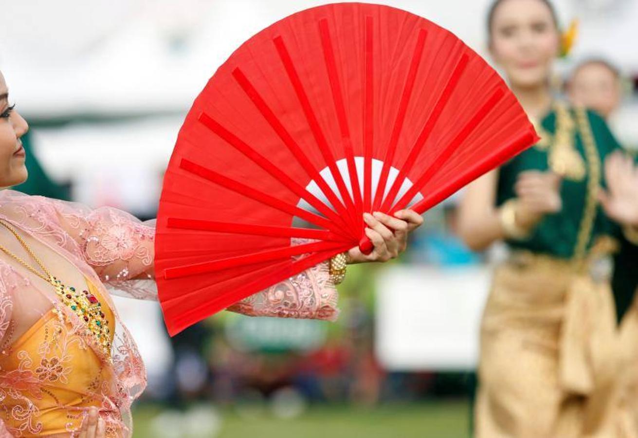 La gente alimenta a los elefantes antes de un partido en el Torneo de Polo de Elefante de la Copa del Rey en un resort ribereño en Bangkok