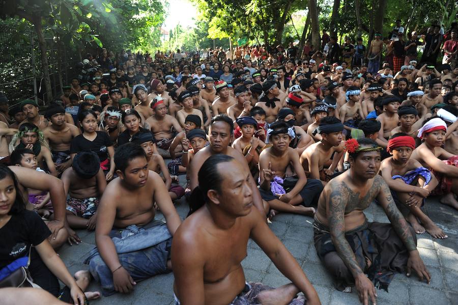 Niños y mayores se esparcen barro por todo su cuerpo durante el tradicional baño de barro conocido como Mebuug.buugan en la aldea de Kedonagn, cerca de Denpasar, en la isla balnearia indonesia de Bali.