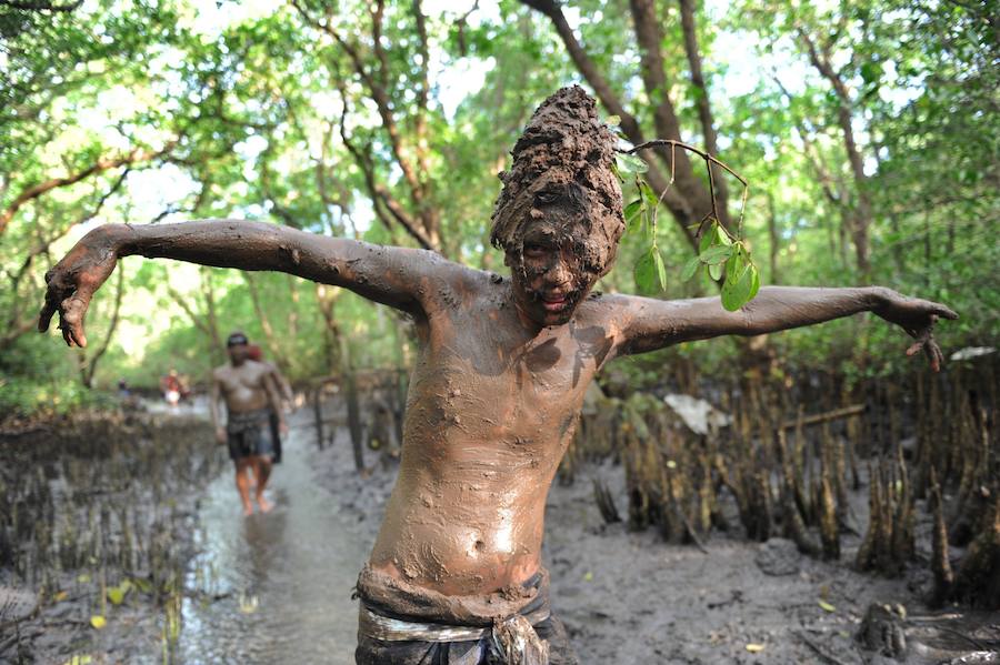 Niños y mayores se esparcen barro por todo su cuerpo durante el tradicional baño de barro conocido como Mebuug.buugan en la aldea de Kedonagn, cerca de Denpasar, en la isla balnearia indonesia de Bali.