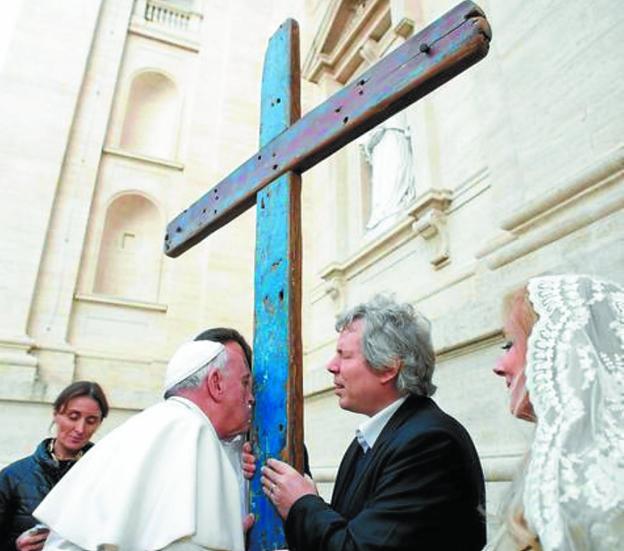El Papa, besando la cruz tras bendecirla y enviarla a recorrer el mundo.