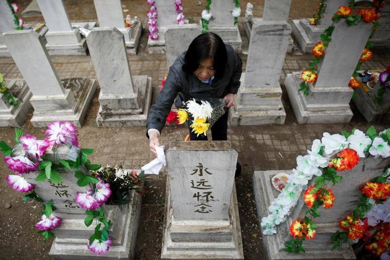 Atienden y limpian las tumbas antes del Festival de Qingming, o el Día de Barrido de Tumbas, en Beijing,