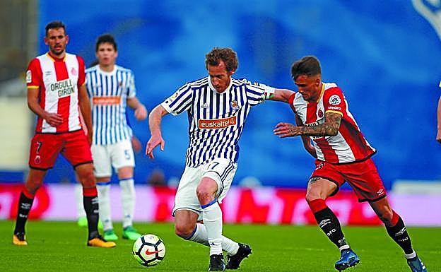 David Zurutuza, que repartió tres asistencias en la segunda mitad, trata de zafarse de un jugador del Girona.