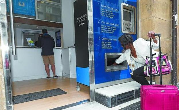 os personas recogen las llaves de su piso turístico en el centro de San Sebastián. 