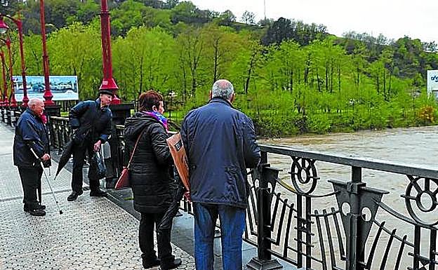 Algunos vecinos contemplan el río. 