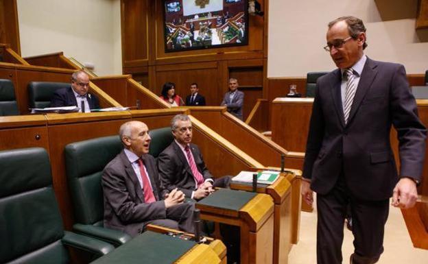 Alfonso Alonso (PP) pasa por delante del lehendakari y Josu Erkoreka (PNV) durante el pleno de este jueves