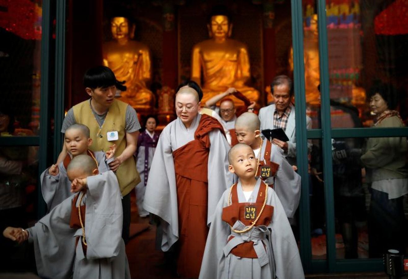 Los monjes principiantes caminan bajo linternas de loto con peticiones de oración cuando se van después de un evento para celebrar el próximo Día de Vesak, el cumpleaños de Buda, en el templo Jogye en Seúl, Corea del Sur, 2 de mayo de 2018.