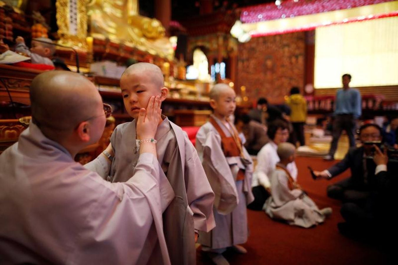 Los monjes principiantes caminan bajo linternas de loto con peticiones de oración cuando se van después de un evento para celebrar el próximo Día de Vesak, el cumpleaños de Buda, en el templo Jogye en Seúl, Corea del Sur, 2 de mayo de 2018.