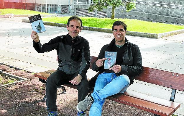 Arretxe y Arriola, mostrando los libros intercambiados. 